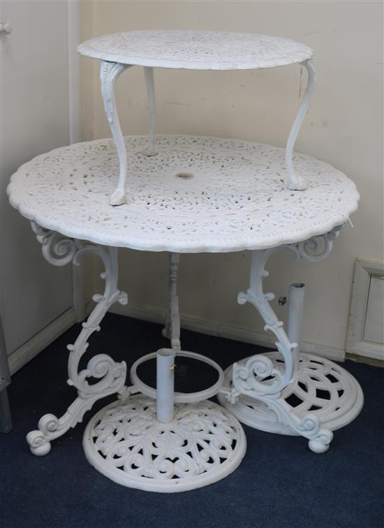 A white painted cast iron garden table and two umbrella bases table w.93cm